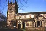 A stone Gothic church with a pinnacled tower