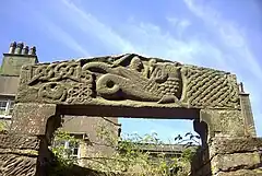 Wall, to west of Priory Church nave, incorporating medieval cross and lintel