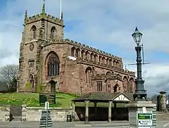 A stone Gothic church with a battlemented tower and body