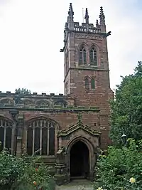 The pinnacled tower and part of the body of a stone Gothic church