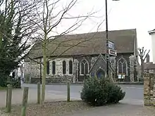 A flint and stone church with a tiled roof