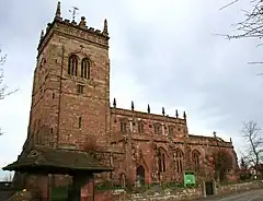 A Gothic stone church with a tower on the left