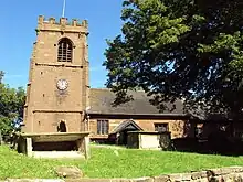 A church with a small body containing rectangular windows and a large Gothic tower