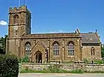 Yellow stone building with square tower.