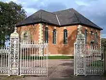 A small Neoclassical brick chapel with a slate roof