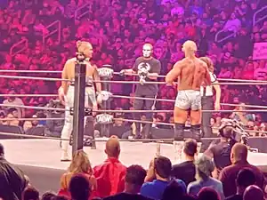 A color photograph of a group of people in a wrestling ring