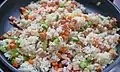 Stir-frying vegetable fried rice in a frying pan