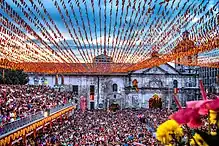 Large crowd outside a colorfully-decorated church