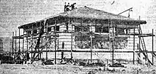 A low stone building under construction