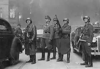 NARA copy #43, IPN copy #43The leader of the grand operationSecond from left Stroop; background either Karl Kaleske [pl] (Stroop's adjutant) or Erich Steidtmann; 2nd from right Heinrich Klaustermeyer; far right Josef Blösche and others at Nowolipie 64 / Smocza 1 intersection