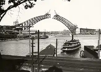 At Lavender Bay wharf, with Sydney Harbour Bridge construction in background, 1930