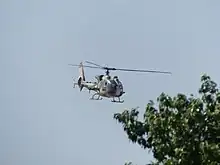 A National Guard's Aérospatiale Gazelle anti-tank helicopter flying during a parade.