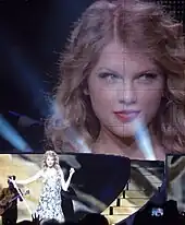 Taylor Swift onstage with a screen behind her