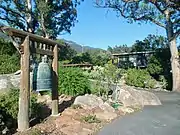 Temple bell (foreground) with the Gatehouse / Bookstore (background right).