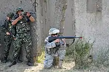 NOVO SELO TRAINING AREA, Bulgaria – Members of the Bulgarian Land Forces 4th Artillery Regiment and U.S. Army Tennessee National Guard 1-181st Field Artillery Battalion provide security for other service members as they sweep through a mock village during military operations in urban terrain training here Aug. 15 as part of Task Force-East.