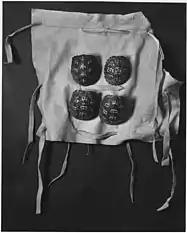 Photograph of cloth with four terrapin shell rattles to be tied around a dancer's leg