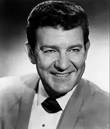 A dark-haired man smiling broadly