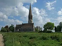 Stone building with spire above a square tower.