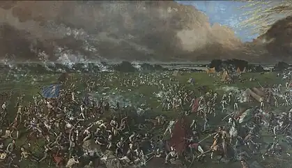 The painting shows many men, some on foot and some on horseback, engaged in hand-to-hand combat.  One man carries the Mexican flag; another carries the flag of the Republic of Texas.  In the background are several tents; behind them is a body of water.