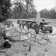 Water-carrying trucks of XII Corps filling up at a water point, 12 July 1944.