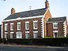 A two-storey Georgian brick house with two storeys, five bays, and a lower single-bay extension on each side