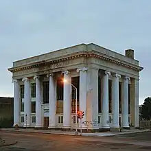 A building on a street corner with Greco-Roman columns and design