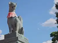 Fox holding a jewel in its mouth at the main gate of the Fushimi Inari shrine