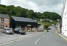 Slightly winding road between buildings near seafront leading uphill to the village