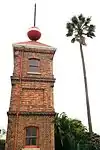 This tower, which was erected in 1883, was used as a repeater-station for harbour signals between the Observatory and Signal Hill. In 1895 the tower was raised from 17 feet to 34 feet. The ball, which was hand-operated at first, was electrified in 1903. Type of site: Time Ball Tower.