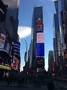 The northern facade of One Times Square as seen in 2017. The facade has various billboards on it.