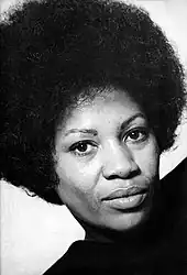 Toni Morrison is pictured in a turtle-neck. She is sporting an afro.