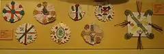 Photograph of eight home-made badges composed of variously coloured crosses and saltires.