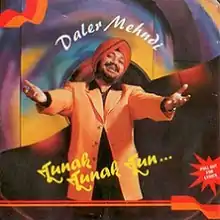 A man in a red turban, yellow vest, and sporting a distinct moustache and beard holds his arms outwards while smiling in front of a colorful-pattern background. The words "Daler Mehndi" appear above his head, and the words "Tunak Tunak Tun" are just below his extended arms.