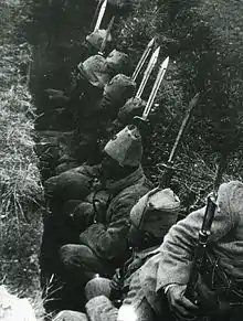 Turkish soldiers in a trench waiting for the order to attack with fixed bayonets on their rifles