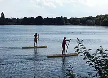 Two lifeguards of the DLRG patrolling a public bathing area of the Feldmochinger See in summer 2022