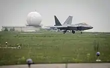 F-22A Raptor taxis at Mihail Kogalniceanu, radar station radome in the background.