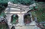 A fragment of Flight 93's metal fuselage with two windows, sitting in a forest