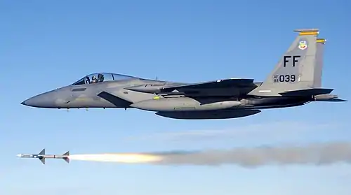 Gray jet aircraft flying above missile following firing of the weapon.