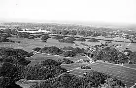 Mogotes in Puerto Rico rising out of pineapple fields in a plain of blanket sand near Coto Sur. The quarry in the left background is 1 kilometer east of Manati.