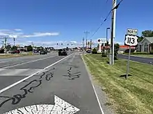 A four-lane divided highway surrounded by businesses