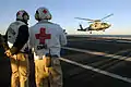 Senior medical officers and flight surgeons wear white with Red Cross emblems.