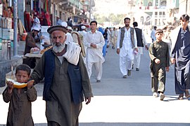 An Afghan father and his child walk down the street from the local farmers market in Asadabad (September 30, 2009).