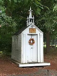  Union Church of All Faiths, located in Hudson, MA, USA. A very small wooden structure resembling a church, painted white, with a small steeple and cross. It is large enough to fit four or five people.