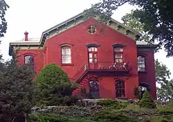 A brick building with pointed roof and landscaped lawn