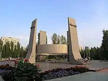 Large abstract monument consisting of four columns connected near midpoint by a circular metal band