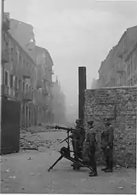 NARA copy #37, IPN copy #35Securing a streetMG08 at the gate on Nowolipie Street intersection with Smocza Street,  looking East. In the back Nowolipie 56.