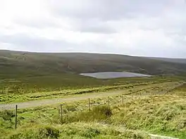 A small rectangular reservoir surrounded by upland