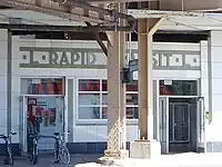 A white Art Deco building with the writing "L RAPID TRANSIT L" on top, partially obscured by an iron column.