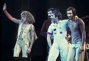 The Who on stage, standing and waving to a crowd