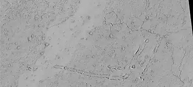 Rootless Cones, as seen by HiRISE under HiWish program.  These group of rings or cones are believed to be caused by lava flowing over water ice or ground containing water ice.  The ice quickly changes to steam which blows out a ring or cone.  Here the kink in the chain may have been caused by the lava changing direction.  Some of the forms do not have the shape of rings or cones because maybe the lava moved too quickly; thereby not allowing a complete cone shape to form.  The location is the Elysium quadrangle.